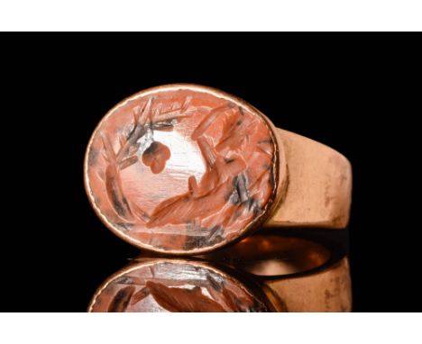 Ca. AD 50 - 300.A Roman red jasper oval intaglio depicting a supine God under a tree. The intaglio is set in a high carat (21