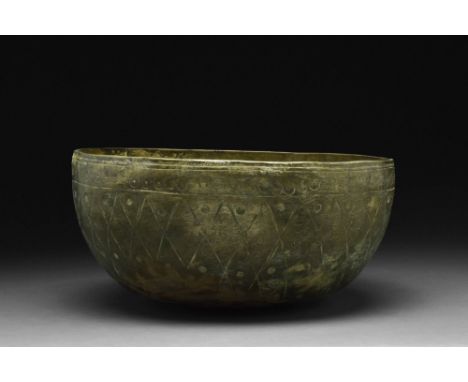 Ca. 10th - 11th century AD.A bronze bowl characterized by a deep body, rounded base, and high sides. The bowl's interior is s