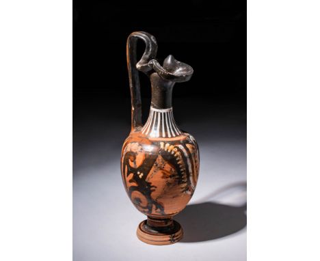 Ca. 350 - 300 BC.An Apulian red-figure oinochoe, the main decoration portrays the face of a woman crowned with a stephane and