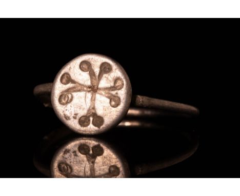 Ca. AD 1000 - 1300.A Late Byzantine silver ring with a round hoop. The bezel depicts a cross with circles at the edges of the