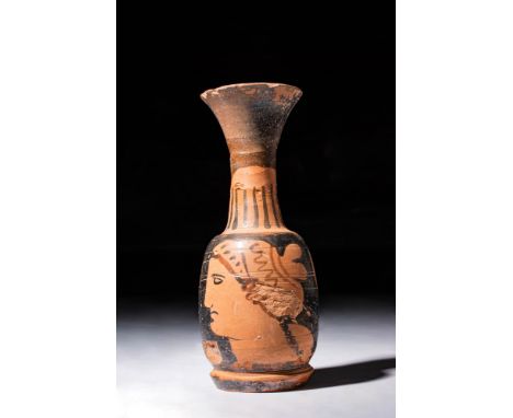 Ca. 350 - 300 BC.An Apulian squat Lekythos with a globular body depicting a head of the "Lady of Fashion" with decorated Sakk