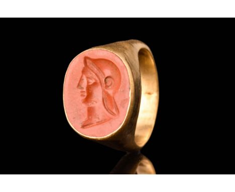 Ca. AD 100 - 300.A gold finger ring of Hening type I, composed of a slender round hoop with a tall bezel set with a carnelian