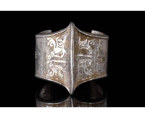 Ca. AD 1100 - 1300.A silver Seljuk penannular bracelet with a central ridge with two opposing decorated panels on the sides, 
