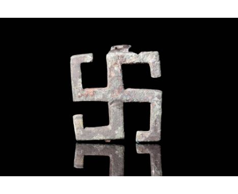 Ca. AD 100 - 300.A bronze swastika brooch with a catchplate on the reverse. The swastika was a symbol of lightning bolts in R