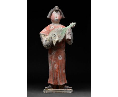 Tang Dynasty, Ca. AD 618 - 907.A Chinese terracotta female musician. The lady is depicted with makeup, wearing a red belted d