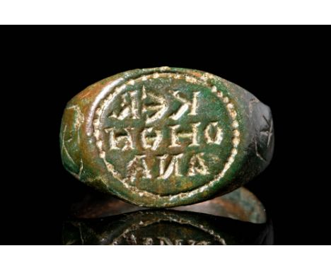 Ca. AD 900 - 1100.A Byzantine bronze finger ring with a round hoop. It has a decorated bezel with inscription (KER OHOH ----)