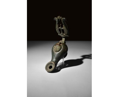 Ca. 4th-6th century AD.An oil lamp meticulously crafted from bronze, boasts a pear-shaped, hollow body that seamlessly conver