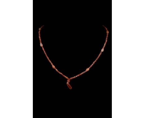 Ca. AD 100 - 300 .A carnelian necklace with tubular and bi-conical beads, featuring a mix of dark and light hues. Carnelian w