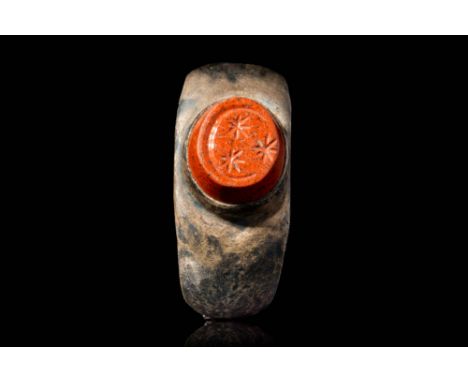 Ca. AD 1 - 200.A Roman silver ring decorated with a polygonal red jasper intaglio engraved with magical subjects, the three l