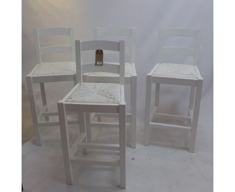A set of four white painted ladder back bar stools with rush seats