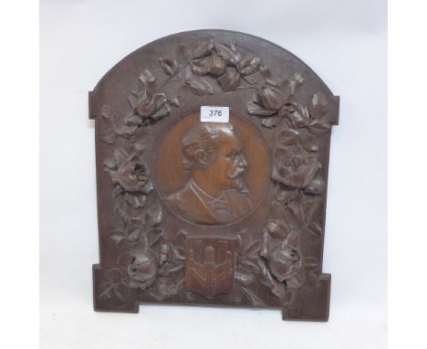 A 19th Century carved oak plaque decorated with roses surrounding a portrait of a gentleman, H:40cm