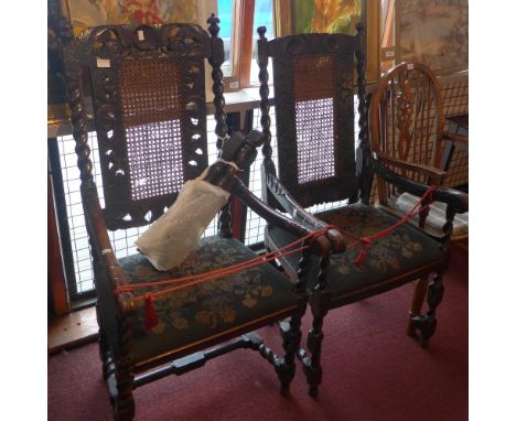 A near pair of Georgian carved oak open elbow chairs with floral tapestry upholstery and raised on barley twist supports join