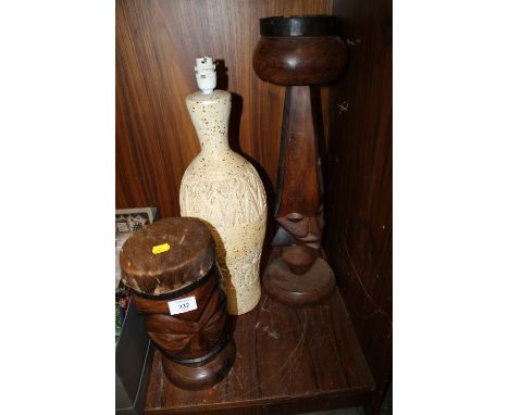 A TRIBAL ART CARVED TREEN ASH TRAY ON STAND, TOGETHER WITH AN ANIMAL SKIN DRUM AND A CERAMIC TABLE LAMP 