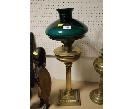 A LARGE BRASS COLUMN OIL LAMP WITH GREEN GLASS SHADE 