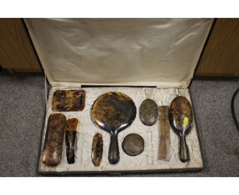 A VINTAGE CASED TORTOISE SHELL DRESSING TABLE SET WITH DRAGON DETAIL