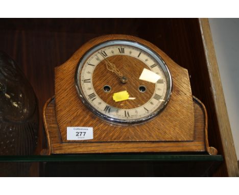 A VINTAGE OAK CASED MANTEL CLOCK