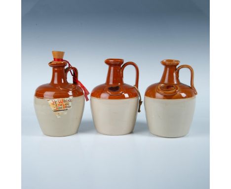 Three two-toned ceramic whisky crocks featuring pour spouts and thumb handles. Two are stamped on the bottom with Ye Monk's W