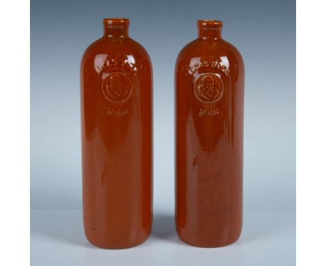 Two tall ceramic bottles finished in a rich caramel-colored glaze, featuring an embossed Lucas Bols logo. Issued: late 19th c