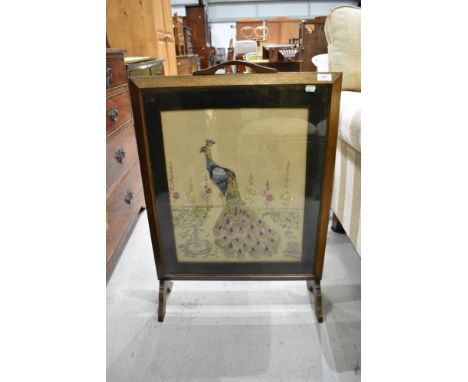 A traditional embroidered firescreen , peacock design