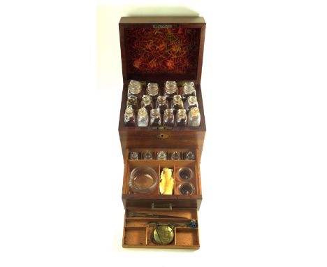 A Regency mahogany military style apothecary cabinet The hinged cover lifts to reveal fifteen assorted clear glass bottles, w