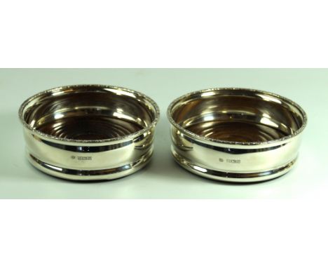 A modern silver matched pair of wine coastersOf round plain form, with an applied rim, to a turned wooden base, loaded, by Ch