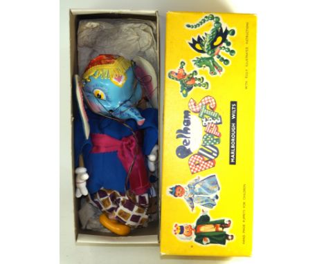A boxed elephant Pelham puppet With hollow moulded head with blue painted features, felt ears, yellow eyes, moulded plastic f