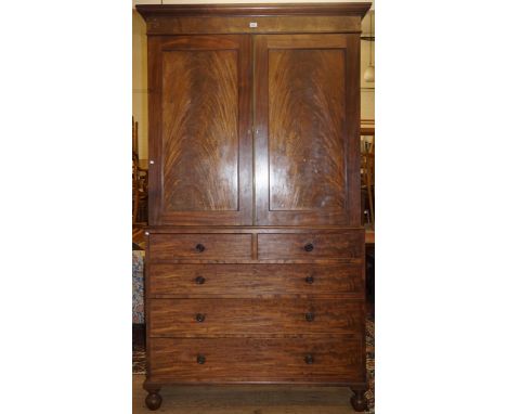 An early Victorian mahogany linen pressThe moulded cornice above two feathered mahogany panelled doors, and two short above t
