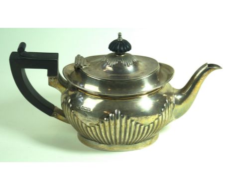A George V hallmarked silver teapot by Mappin & WebbThe semi fluted oval form in the Georgian taste, with ebonised finial and