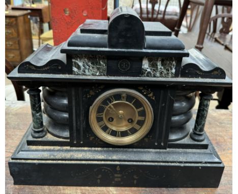 A black slate mantle clock of architectural form with Roman numerals 
