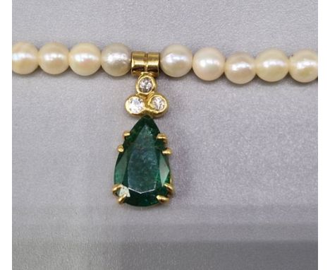 A cultured pearl necklace with 18ct gold diamond and emerald set teardrop pendant, 46cms long 