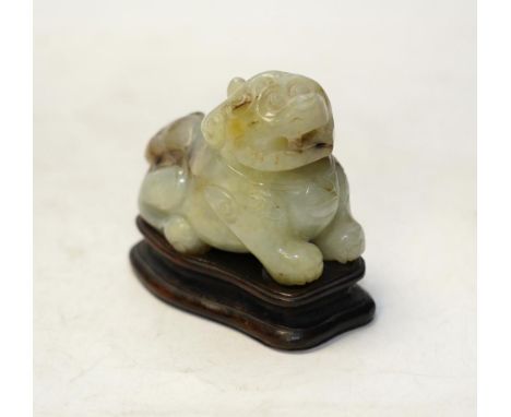 A Chinese carved jade ‘lion dog’ and stand, 8cm tall. Condition fair to good.