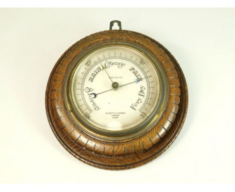 NEGRETTI & ZAMBRA. A Negretti & Zambra aneroid barometer in carved wooden case. Diameter of case 21.5cm. (G.A. 0501044)Please