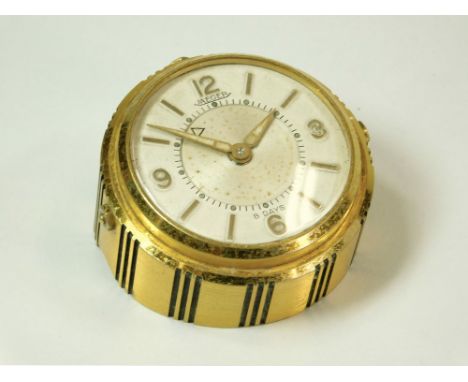 JEAGER CLOCK. A Jeager eight day alarm clock in sloping gilt brass case, No.683. Diameter 5cm.Please note: All watches and cl