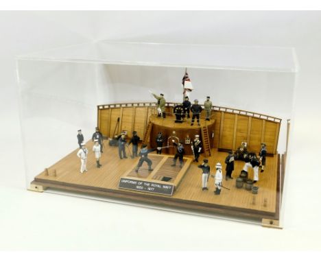 SHOWCASE MODEL. A showcase model showing uniforms of the Royal Navy 1850-1977. Comprising 19 figures on a portion of wooden s