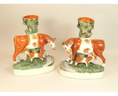 STAFFORDSHIRE SPILLS. A pair of 19th century Staffordshire cow & calf spills. Height 27cm. (Some loss to ears & horns, please