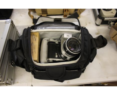 A Pentacon Six camera in carrying bag with various accessories 