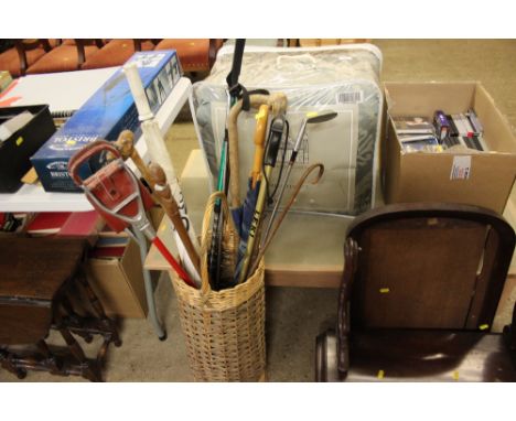 A wicker stick stand and contents of various walking sticks, umbrellas, shooting stick, golf clubs etc.