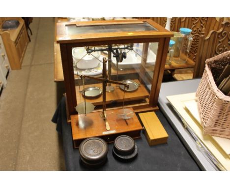 A set of brass scales in mahogany case; one other set of scales and various weights 