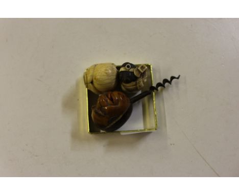 A corkscrew; a Netsuke; and a cane handle in the form of a hand holding a ball