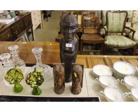 A carved hardwood figure converted to a table lamp base; and a pair of carved hard wood book ends