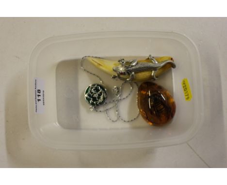 A box containing amber style pendant; jade coloured pendant and one other
