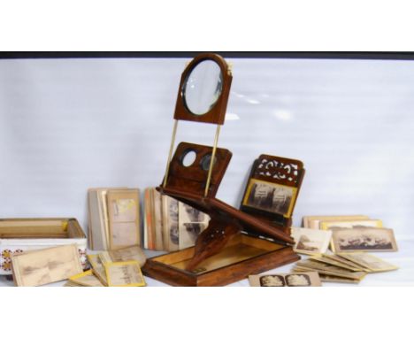 Victorian walnut table viewer and a collection of viewing cards.CONDITION REPORT: The lenses are pitted and stained with age.