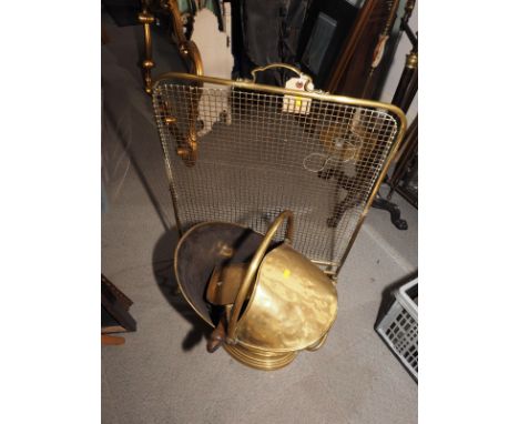 A brass coal scuttle, a coal shovel, a brass wire mesh firescreen and a brass standard lamp with reeded stem 
