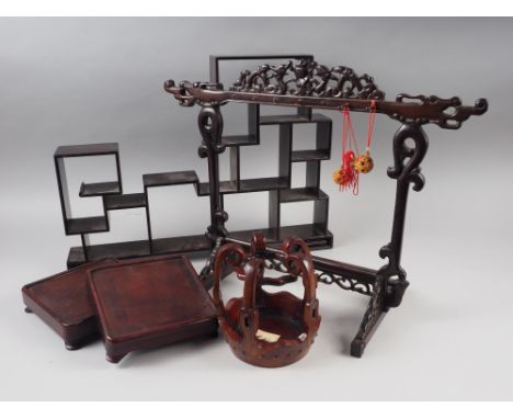 A Chinese hardwood drum-shaped vase stand, two plain square stands, a similar display rack and a display shelf 