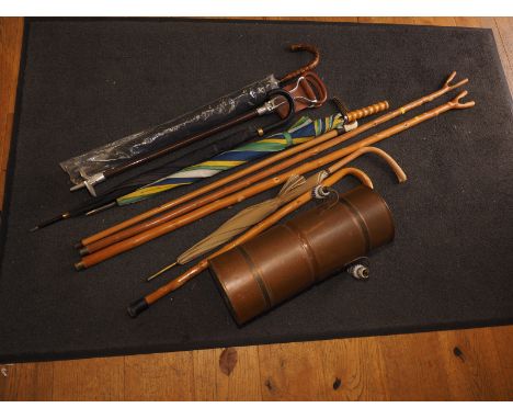 Four umbrellas of various sizes, four walking sticks, a shooting stick, a brass stick stand, 20" high, and another stick stan