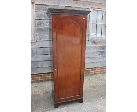 A figured mahogany 'sentry box' hall wardrobe enclosed arched top panel door, on bracket feet, 27" wide x 18" deep x 69 1/2" 