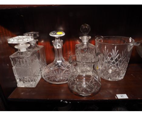 Four decanters, a glass punch bowl with twelve cups and ladle, a crystal ice bucket and a water jug 