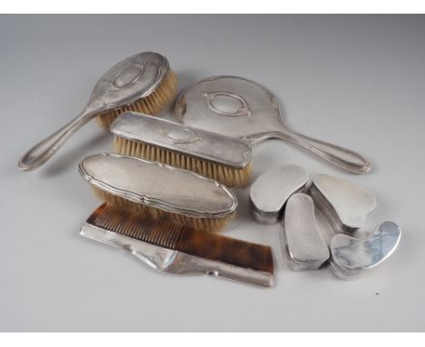 A three-piece silver backed brush and mirror set, a similar comb and brush and a set of four Indian white metal pill boxes 