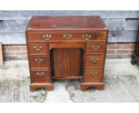 A late Georgian mahogany kneehole desk, fitted one long drawer over central recess and six flanking drawers, on bracket feet,