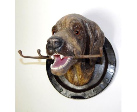 Works of Art: A Ceramic Wall Hanging Fox Hound Whip Rack, in the form of a Fox Hound holding a four prong whip rack in its mo